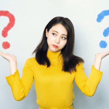 Identity Guard vs LifeLock comparison identity theft protection services woman holding in hands two question marks red and blue 